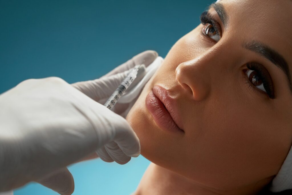 cosmetologist-using-syringe-correct-female-face